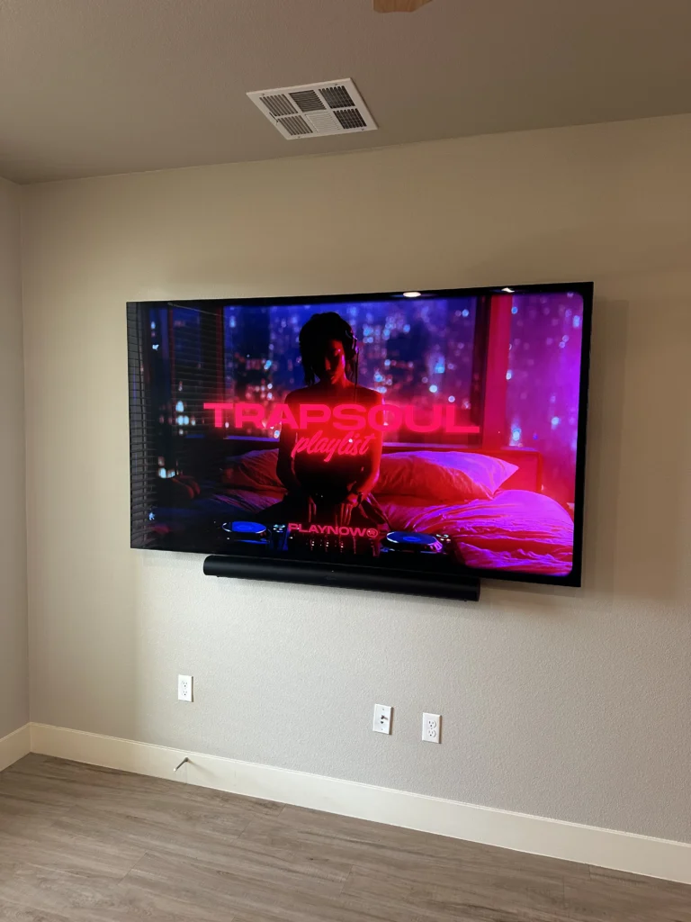 Large TV and soundbar on drywall, cables out of sight.