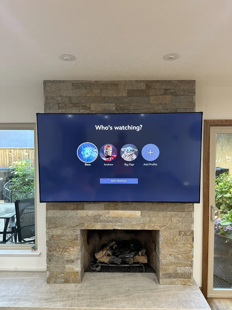 TV mounted on a stacked-stone fireplace, anchored into the stone. No cables showing.