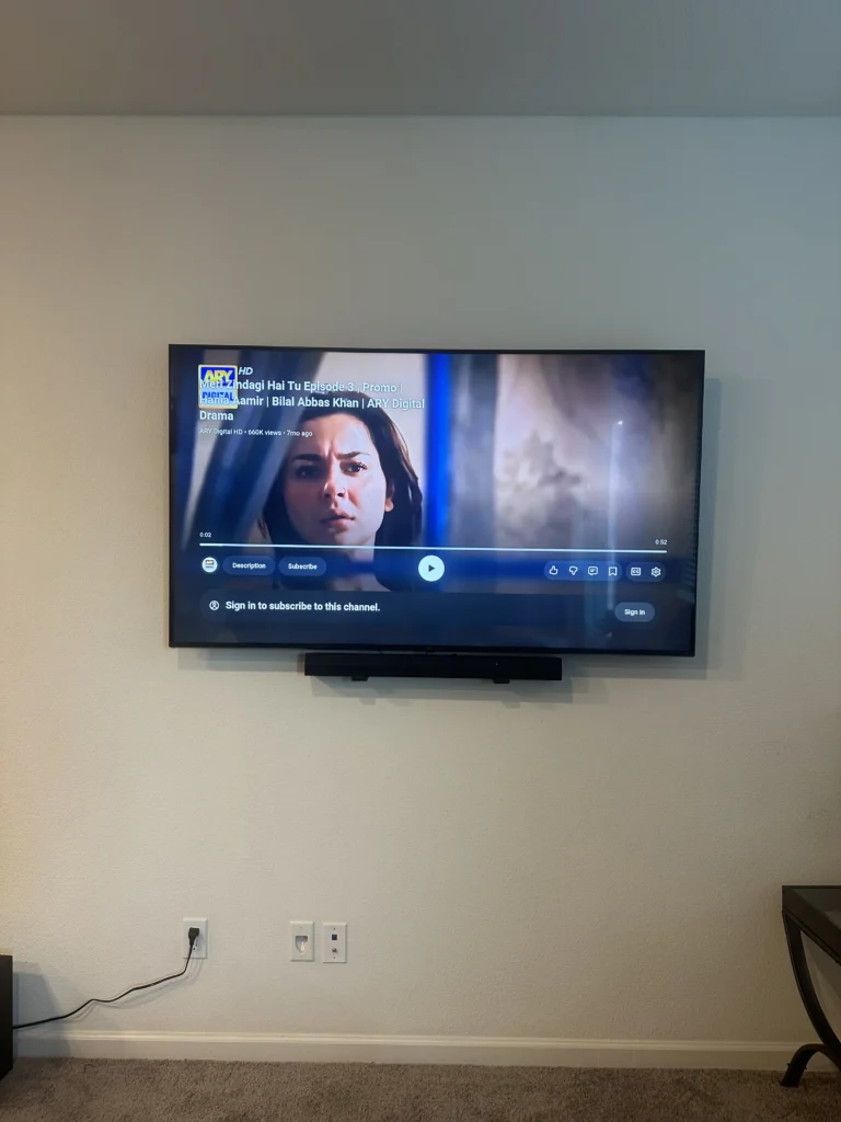 TV with a soundbar mounted under it. No cables on the wall.