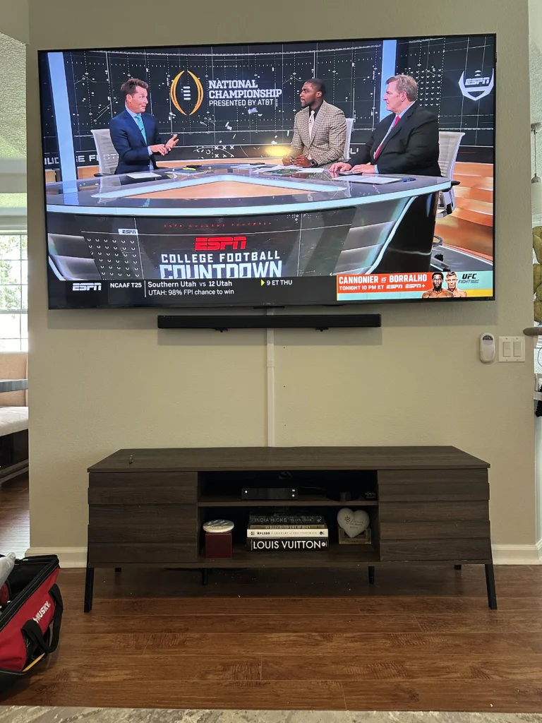 Large TV with a soundbar mounted under it.